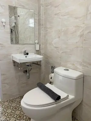 a bathroom with a white toilet and a sink at Guest Room Bang Tao MMA in Ban Thalat Choeng Thale