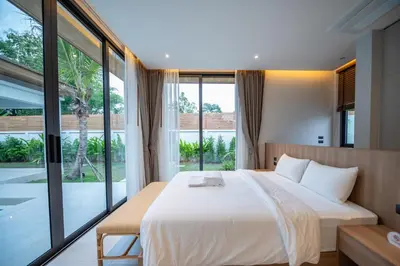 a bedroom with a large bed and large windows at Mouana Breeze Mai Khao 4-bedroom Pool Villa 9918 in Mai Khao Beach