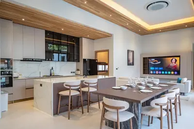 a kitchen with a table and chairs in a room at Mouana Breeze Mai Khao 4-bedroom Pool Villa 9918 in Mai Khao Beach