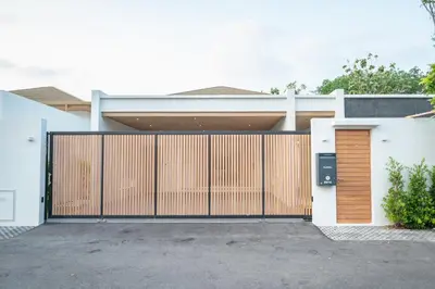 a house with a gate and a driveway at Mouana Breeze Mai Khao 4-bedroom Pool Villa 9918 in Mai Khao Beach