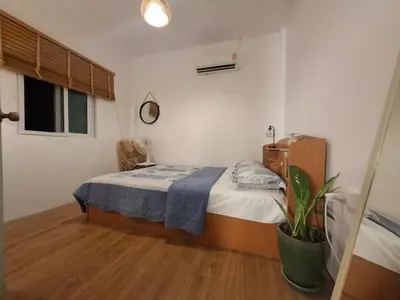 a bedroom with a bed and a potted plant at The Grove Guesthouse in Patong Beach