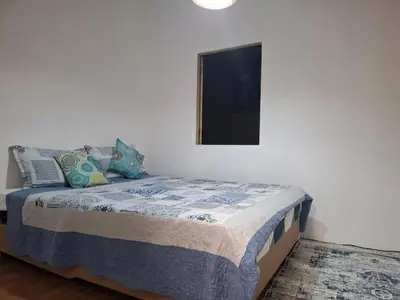 a bedroom with a bed with a tv on the wall at The Grove Guesthouse in Patong Beach