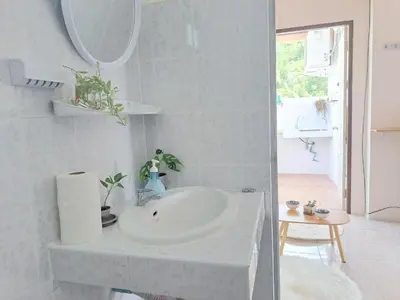 a white bathroom with a sink and a mirror at The Grove Guesthouse in Patong Beach