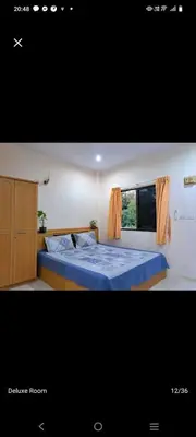 a bedroom with a blue bed and a window at The Grove Guesthouse in Patong Beach