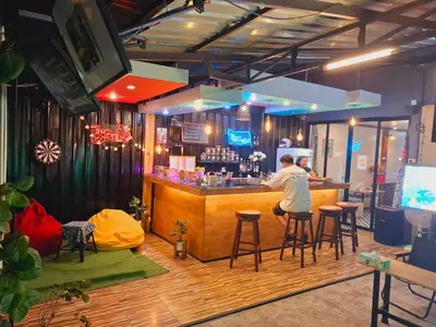 a man sitting at a bar in a restaurant at The Grove Guesthouse in Patong Beach