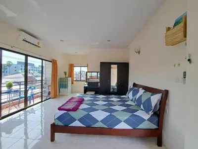 a bedroom with a bed with a blue and white checkered bedspread at The Grove Guesthouse in Patong Beach