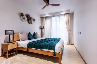 a bedroom with a bed and a large window at Beachfront 2-bd apartment Laguna in Bang Tao Beach