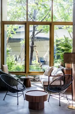 a room with chairs and tables and a large window at Beachfront 2-bd apartment Laguna in Bang Tao Beach