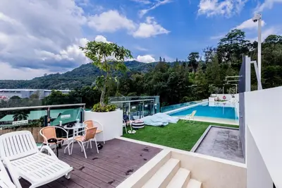 a patio with a table and chairs and a swimming pool at 1-bd apartment on Kamala beach in Kamala Beach