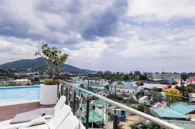 a balcony with a view of a city and a pool at 1-bd apartment on Kamala beach in Kamala Beach