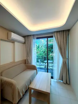 a bedroom with a couch and a table and a balcony at 1-bd apartment on Kamala beach in Kamala Beach