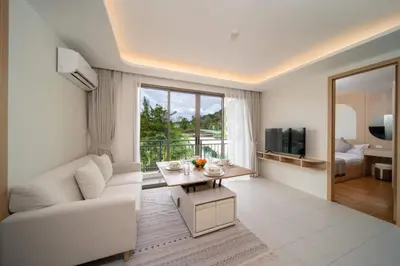 a living room with a white couch and a television at \u5168\u65b0\u4e8c\u5367\u516c\u5bd3\u73b0\u4ee3\u98ce\u683c in Phuket Town