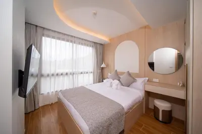 a bedroom with a large bed and a mirror at \u5168\u65b0\u4e8c\u5367\u516c\u5bd3\u73b0\u4ee3\u98ce\u683c in Phuket Town