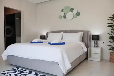 a bedroom with a large bed with two pillows on it at Rawai Duplex Style Luxurious 4-BR Private Pool Villa in Rawai Beach
