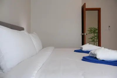 a white bed with two pillows on top of it at Rawai Duplex Style Luxurious 4-BR Private Pool Villa in Rawai Beach