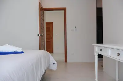 a white bedroom with a bed and a desk at Rawai Duplex Style Luxurious 4-BR Private Pool Villa in Rawai Beach