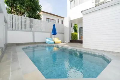 a swimming pool in the backyard of a house at Duplex Style 3-BR Corner Private Pool Villa in Ban Pak Lak