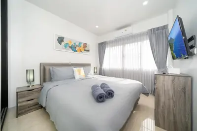 a bedroom with a large white bed with blue towels on it at Duplex Style 3-BR Corner Private Pool Villa in Ban Pak Lak
