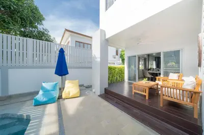 a patio with a bench and a table at Duplex Style 3-BR Corner Private Pool Villa in Ban Pak Lak