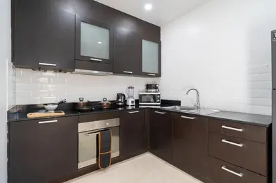 a kitchen with dark brown cabinets and a sink at Duplex Style 3-BR Corner Private Pool Villa in Ban Pak Lak