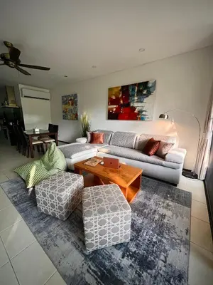 a living room with a couch and a table at Bangtao Beach Gardens in Surin Beach
