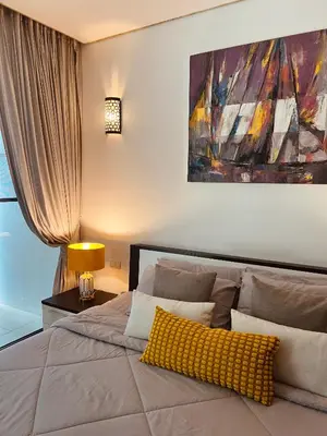 a bedroom with a bed with a yellow pillow on it at Bangtao Beach Gardens in Surin Beach
