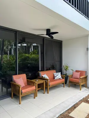 a patio with two chairs and a table and glass doors at Bangtao Beach Gardens in Surin Beach