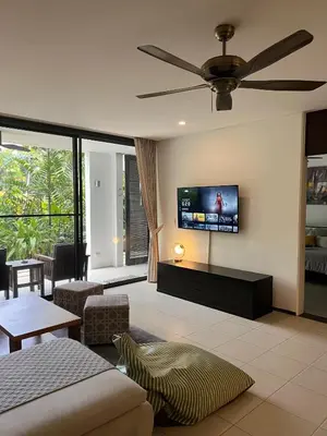 a living room with a flat screen tv on the wall at Bangtao Beach Gardens in Surin Beach
