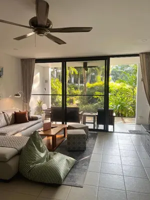 a living room with a couch and a ceiling fan at Bangtao Beach Gardens in Surin Beach