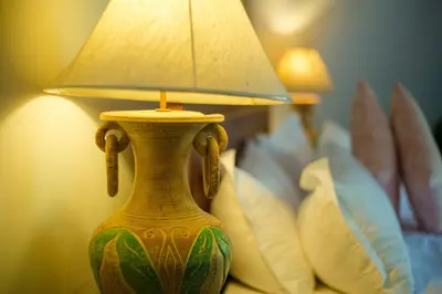 a vase with a lamp on a table with pillows at Coco palace resort in Rawai Beach