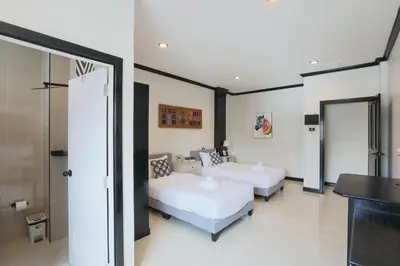 a bedroom with two beds and a sliding glass door at Wink City 2 Patong Center close to the Beach in Patong Beach