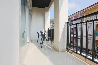 a balcony with two chairs and a table on it at Wink City 2 Patong Center close to the Beach in Patong Beach