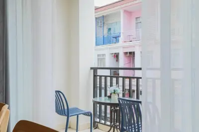 a table and chairs in a room with a balcony at Wink City 2 Patong Center close to the Beach in Patong Beach