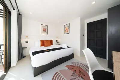 a bedroom with a bed and a table and a chair at Wink Centre House 10 Patong Beach in Patong Beach