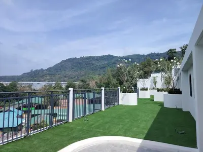 a balcony with green grass and a view of a mountain at now condo near beach 2bedroom in Kamala Beach