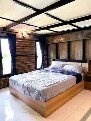 a bedroom with a large bed with a wooden headboard at Water Lily Spa Bungalows by Rawai Beach in Rawai Beach