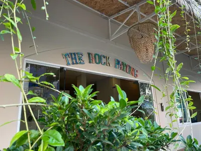 a sign that reads the rock palace behind plants at The Rock Patong Comfort Stay in Patong Beach