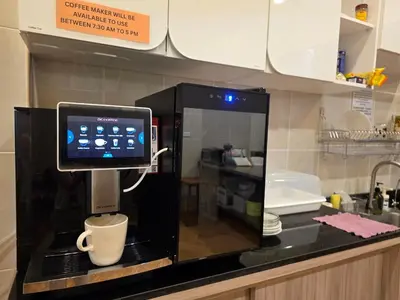 a coffee machine with a cup in a microwave at The Rock Patong Comfort Stay in Patong Beach