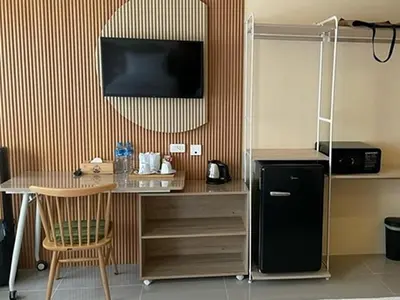 a kitchen with a table and a black refrigerator at The Rock Patong Comfort Stay in Patong Beach