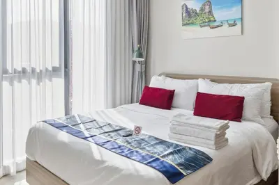 a bedroom with a bed with red and blue pillows at THE BASE Rise Resort Style 1 & 2 Bedrooms in Ban Rangeng