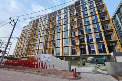 a large building with a sign in front of it at THE BASE Rise Resort Style 1 & 2 Bedrooms in Ban Rangeng