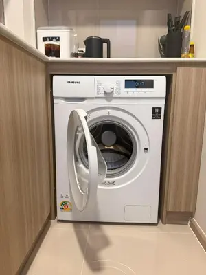 a washing machine in a kitchen under a counter at THE BASE Rise Resort Style 1 & 2 Bedrooms in Ban Rangeng