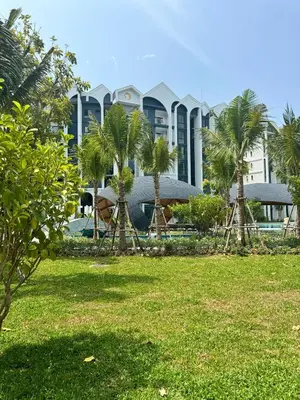 a resort with palm trees and a building at Phuket apartment in Nai Yang Beach