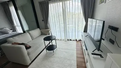 a living room with a white couch and a television at Phuket apartment in Nai Yang Beach
