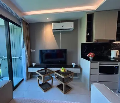 a living room with a television and a table at Seaview, 1 bd, Surin beach in Surin Beach