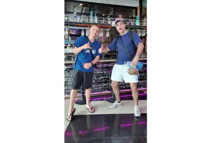 two men standing in front of a supermarket shelf at Hangover #1 Hostel Patong in Patong Beach