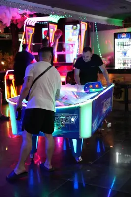 a group of men playing a game at a ping pong table at Hangover #1 Hostel Patong in Patong Beach