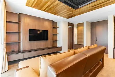 a living room with a couch and a flat screen tv at Chariot by Villacarte in Layan Beach