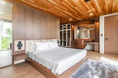 a bedroom with a large bed and a kitchen at Chariot by Villacarte in Layan Beach