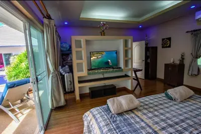 a living room with a tv and a bed and a room at Villa 320m2 Piscine privée 4 chambres à Kamala in Kamala Beach